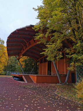 St. Petersburg Elagin Adası 'ndaki sonbahar parkındaki ağaçların arasında bir açık hava ahşap tiyatro..