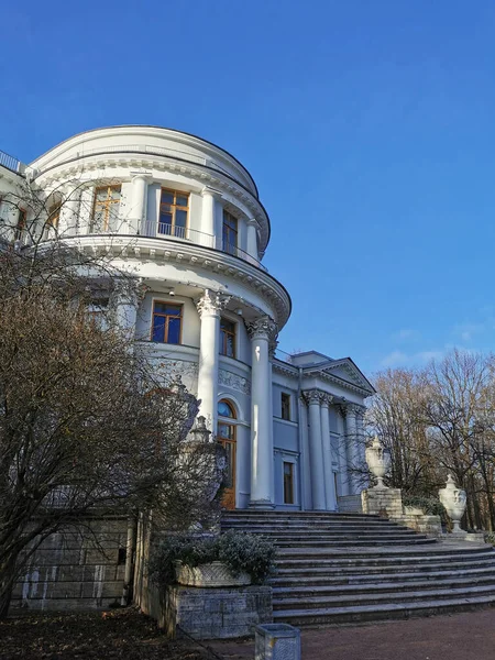 상트페테르부르크의 공원에서 구름이 하늘을 배경으로 낙엽이 떨어지는 나무와 관목들 사이의 — 스톡 사진