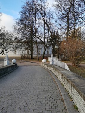 Kaldırım taşlarından Elaginoostrovsky Sarayı 'na giriş yapraksız ağaçlar, taş toplar ve güzel fenerlerle çevrili St. Petersburg sonbahar parkında bulutlu mavi bir gökyüzüne karşı..