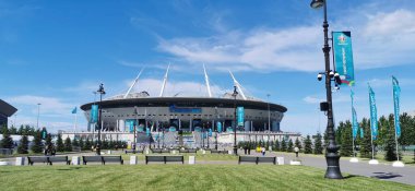 EURO 2020 Avrupa Futbol Şampiyonası 'nın olduğu sabah St. Petersburg' daki Gazprom Arena Stadyumu 'nun önündeki çimen ve banklar bulutlu mavi gökyüzüne karşı..