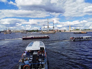 Turistli tekne ve yatlar, St. Petersburg 'daki donanma günü için savaş gemileri ve yelkenlileri görmek üzere Neva' ya gidiyor..