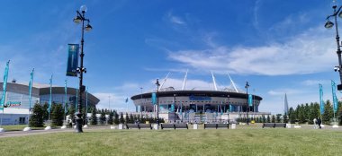 EURO 2020 Avrupa Futbol Şampiyonası 'nın olduğu sabah St. Petersburg' daki Gazprom Arena Stadyumu 'nun önündeki çimen ve banklar bulutlu mavi gökyüzüne karşı..