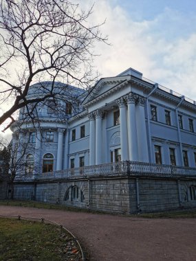 Maldivler. Kırmızı bluzlu güzel bir sarışın kız ve beyaz etekli bir kız beyaz kum, shezloglar ve turkuaz suyla Hint Okyanusu kıyısına bisikletle geldiler.. 