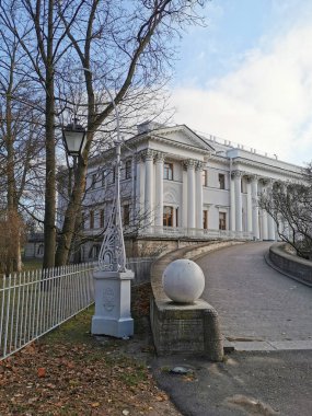 Saint-Petersburg 'da. - Rusya. Yaprakları donmakta olan çiçekli vazolar Elaginoostrovsky Sarayı 'nın arka planında ve St. Petersburg sonbahar parkında mavi gökyüzünde..