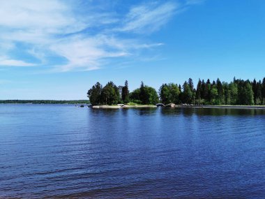 Vyborg şehrinin Monrepos Parkı 'ndaki Vyborg Körfezi' nin pitoresk sahilindeki gözlem güvertesinden mavi bulutlu bir gökyüzünün arka planına bakın..