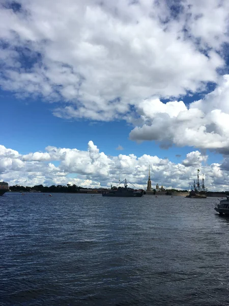 ネヴァ川の水域には 旗を掲げた軍艦と ピーターとポール要塞を背景にサンクトペテルブルクの海軍パレードに参加するために到着したセーリング船Poltavaがあります — ストック写真