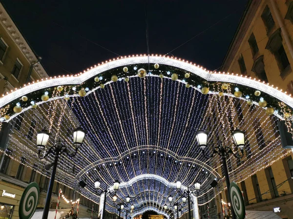 サンクトペテルブルクのマラヤ サドバヤ通りでは クリスマスのためのお祝いの照明で飾られ 黒い空に対する古代のランタンの間に新年 — ストック写真