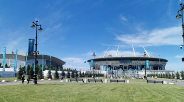 EURO 2020 Avrupa Futbol Şampiyonası 'nın olduğu sabah St. Petersburg' daki Gazprom Arena Stadyumu 'nun önündeki çimen ve banklar bulutlu mavi gökyüzüne karşı..