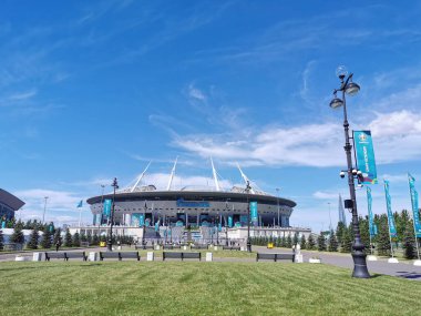 EURO 2020 Avrupa Futbol Şampiyonası 'nın olduğu sabah St. Petersburg' daki Gazprom Arena Stadyumu 'nun önündeki çimen ve banklar bulutlu mavi gökyüzüne karşı..