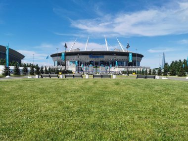 EURO 2020 Avrupa Futbol Şampiyonası 'nın olduğu sabah St. Petersburg' daki Gazprom Arena Stadyumu 'nun önündeki çimen ve banklar bulutlu mavi gökyüzüne karşı..