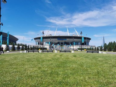 EURO 2020 Avrupa Futbol Şampiyonası 'nın olduğu sabah St. Petersburg' daki Gazprom Arena Stadyumu 'nun önündeki çimen ve banklar bulutlu mavi gökyüzüne karşı..