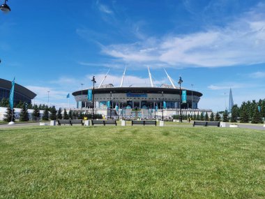 EURO 2020 Avrupa Futbol Şampiyonası 'nın olduğu sabah St. Petersburg' daki Gazprom Arena Stadyumu 'nun önündeki çimen ve banklar bulutlu mavi gökyüzüne karşı..