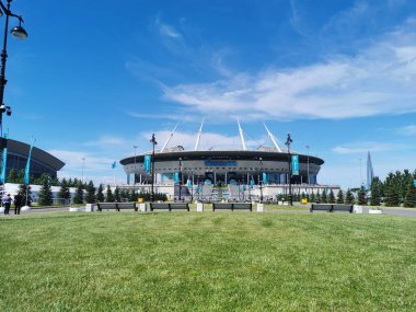 EURO 2020 Avrupa Futbol Şampiyonası 'nın olduğu sabah St. Petersburg' daki Gazprom Arena Stadyumu 'nun önündeki çimen ve banklar bulutlu mavi gökyüzüne karşı..