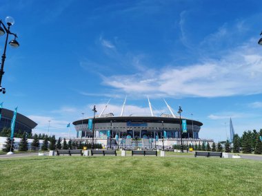 EURO 2020 Avrupa Futbol Şampiyonası 'nın olduğu sabah St. Petersburg' daki Gazprom Arena Stadyumu 'nun önündeki çimen ve banklar bulutlu mavi gökyüzüne karşı..