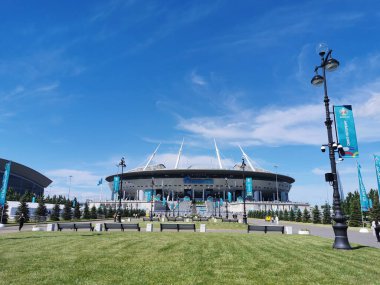 EURO 2020 Avrupa Futbol Şampiyonası 'nın olduğu sabah St. Petersburg' daki Gazprom Arena Stadyumu 'nun önündeki çimen ve banklar bulutlu mavi gökyüzüne karşı..