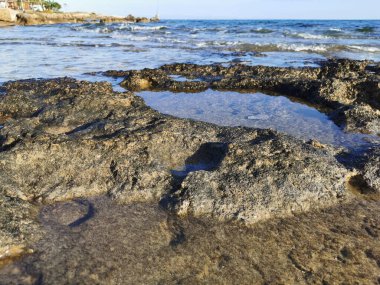 Protaras. Famagusta bölgesi. Kıbrıs. Akdeniz kıyıları, uzun donmuş lavlar, mavi gökyüzüne karşı deniz suyu bulunan yerlerde..