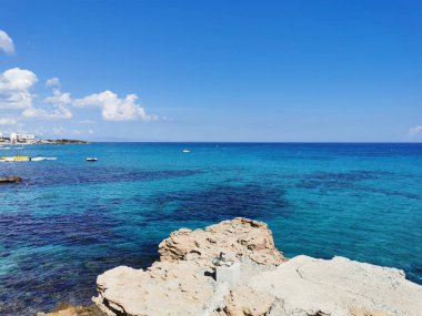 Protaras. Kıbrıs. İncir Ağacı Koyu 'nun kumlu plajı, insanlar güneşlenir ve şemsiyeler altında dinlenir, Akdeniz' de yüzerler..