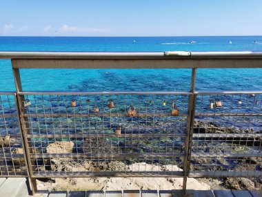 Protaras. Kıbrıs. İncir Ağacı Koyu 'nun kumlu plajı, insanlar güneşlenir ve şemsiyeler altında dinlenir, Akdeniz' de yüzerler..