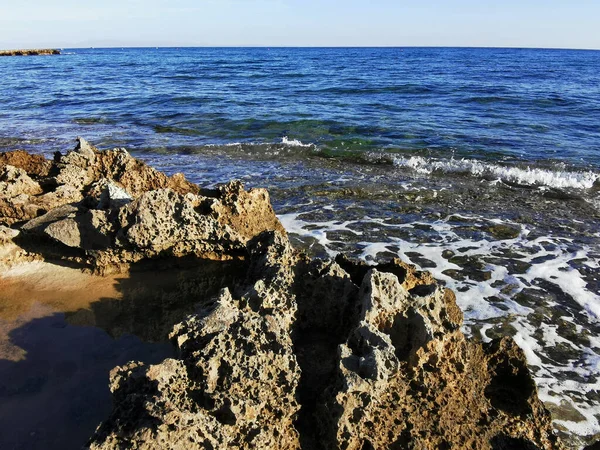 Protaras 法马古斯塔地区塞浦路斯 地中海沿岸长期硬化的熔岩 多孔的 尖锐的海岸 在蓝天的映衬下涌来的波浪 — 图库照片
