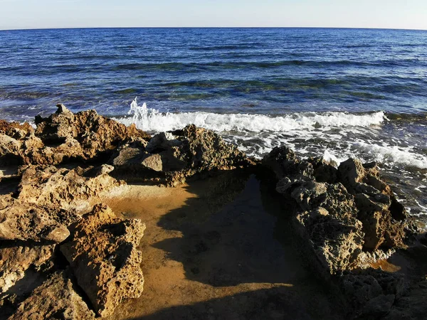 Protaras 法马古斯塔地区塞浦路斯 地中海沿岸长期硬化的熔岩 多孔的 尖锐的海岸 在蓝天的映衬下涌来的波浪 — 图库照片