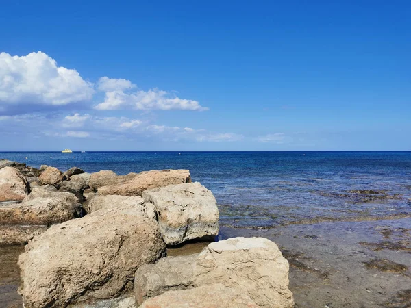 Protaras 法马古斯塔地区塞浦路斯 巨大的石头 长期硬化的熔岩 以大海为背景的地中海沿岸有一艘游艇 蓝天有云彩 — 图库照片