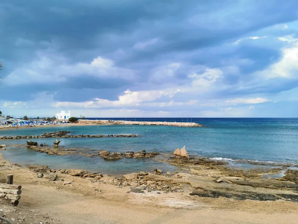 Protaras 法马古斯塔地区塞浦路斯 岩石海岸 有沙子 圣尼古拉斯神殿神奇工作者在一个戏剧性的天空的背景下 — 图库照片