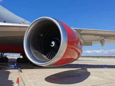 Kırmızı bir uçak motoru Paphos havaalanında bulutlu güzel mavi bir gökyüzüne karşı duruyor..