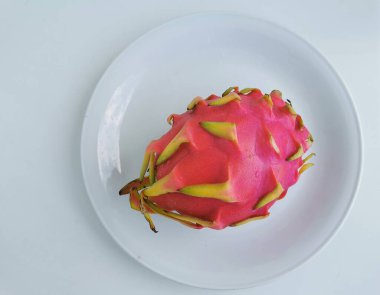 Protaras. Famagusta bölgesi. Cyprus. Pitaya, veya pitahaya (ejderha gözü) - Hylocereus cinsinden kaktüsün beyaz bir tabakta duran su damlalarındaki meyvesi..