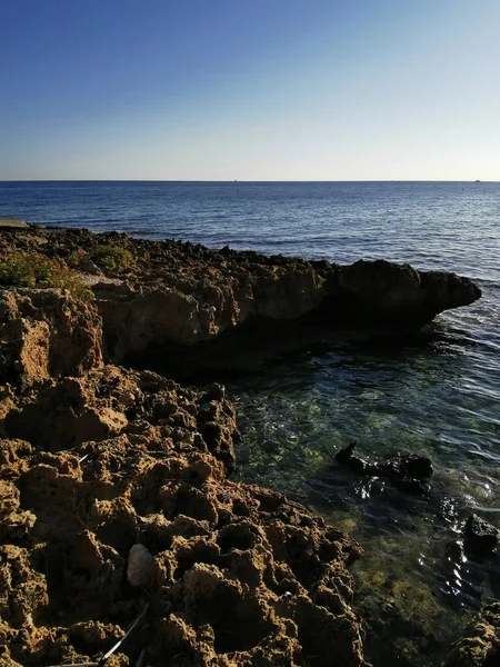 Protaras 法马古斯塔地区塞浦路斯 地中海沿岸长期硬化的熔岩 多孔的 尖锐的海岸 在蓝天的映衬下涌来的波浪 — 图库照片