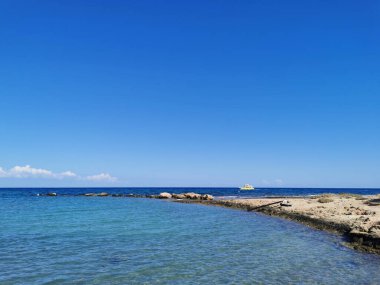 Protaras. Kıbrıs. Rıhtım, Akdeniz körfezinde küçük gemileri, yatları ve tekneleri olan liman dramatik bir gökyüzünün arka planına karşı..