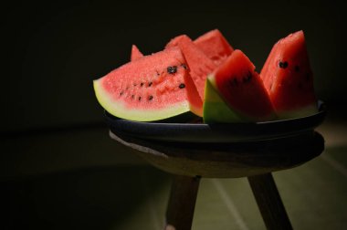 Sliced watermelon on a plate and old chair with natural light