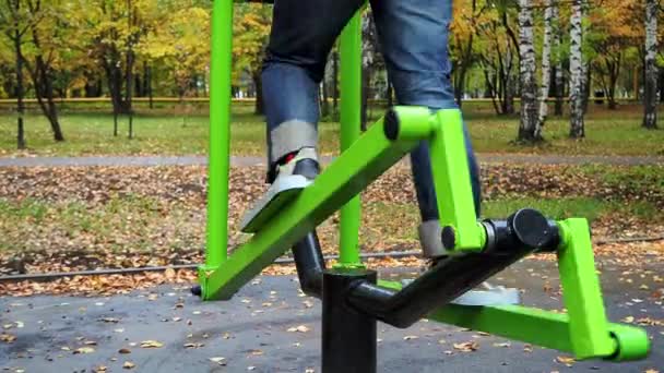 Les gens vont dans le sport, vélo d'appartement sur le terrain de jeux dans le parc en plein air. — Video