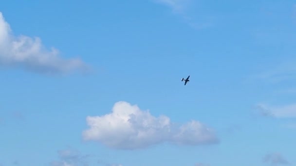 Samolot tłokowy wykonuje akrobacje na niebie nad miastem. Pokazy lotnicze ku czci dnia miasta — Wideo stockowe