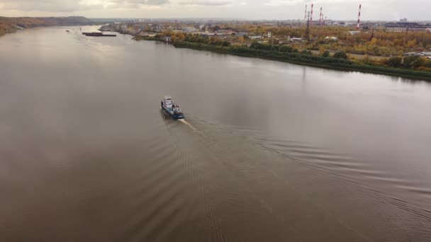 モーターボート、タグボートは秋に川に沿って行く。飛行士からのビデオ撮影ドローンからの撮影空中での撮影 — ストック動画