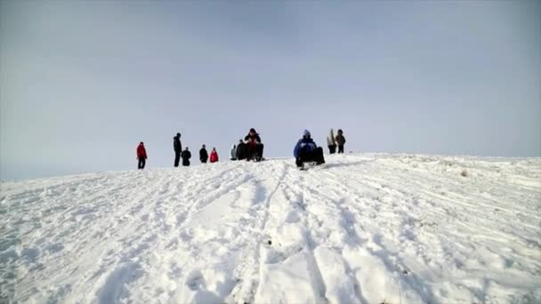 Άνθρωποι, παιδιά να κατεβαίνουν το λόφο το χειμώνα.. — Αρχείο Βίντεο