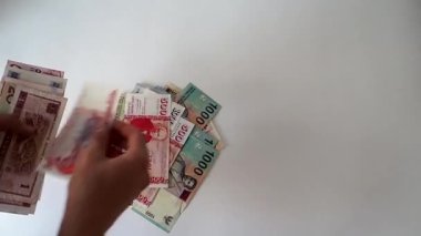 Kağıt paralar, dünyanın farklı ülkelerinden gelen paralar. Farklı ülkelerin para birimleri. Bir insan kağıt para sayar.