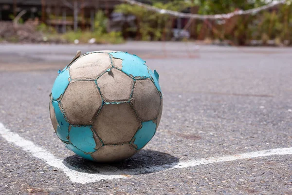 old soccer ball on street floor