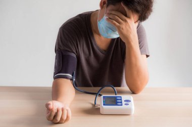 Stresli adam, el bilgisayarıyla kan basıncını ölçtü ve basıncın normalden yüksek olduğunu gördü.