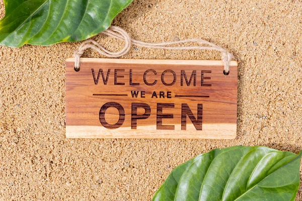 open sign board on sand