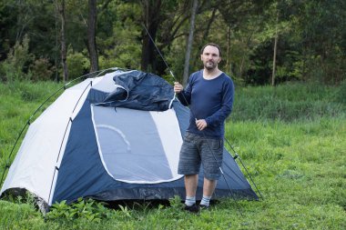Brezilya 'da kamp çadırının önünde duran bir adam. 