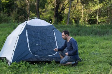Brezilya 'da kamp çadırının önünde duran bir adam. 