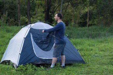 Brezilya 'da kamp çadırının önünde duran bir adam. 
