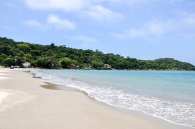 View of the beach Ponta do Papagaio with blue sky and clouds in Santa Catarina