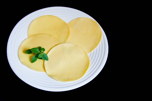 Siyah arka planı olan beyaz bir tabakta çiğ pastelina.