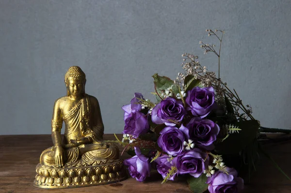 Mor çiçekli altın Buda heykeli