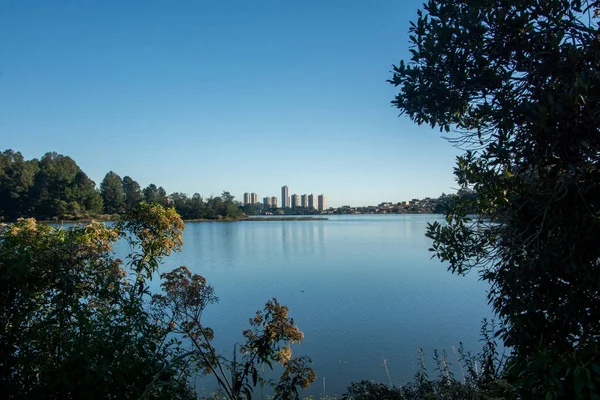 Arka planda şehir olan bir göl manzarası