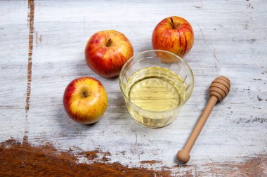 honey and apples on top of a rustic table