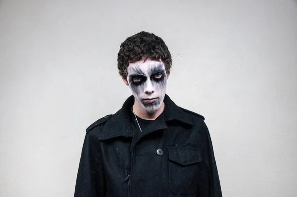 Young man with facial paint on a white background