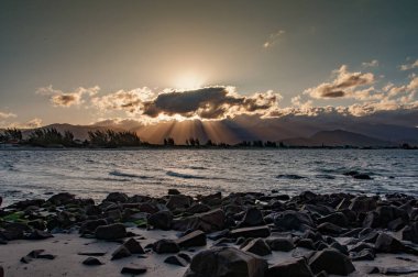 Sahilin arka planında dağlar olan manzarası