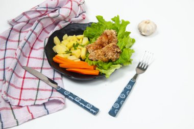 Patates, havuç, marul ve kızarmış tavukla güzel bir salata tabağı.